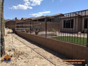 Installation of new black barrier mesh on an existing fence, a top-down snake fence modification by Arizona Snake Fence LLC in Tucson, AZ