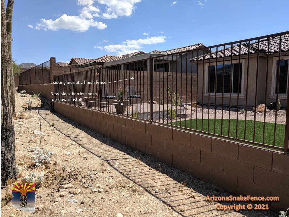 Installation of new black barrier mesh on an existing fence, a top-down snake fence modification by Arizona Snake Fence LLC in Tucson, AZ