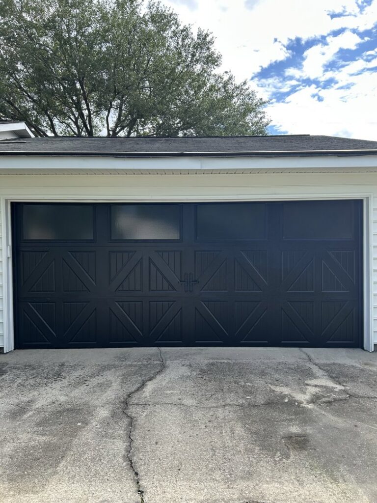 A black carriage-style garage door with decorative hardware by Chase Door Systems in Summerville, SC.