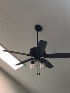 A black ceiling fan with three glass light fixtures installed by C. C. Taylor Electric LLC in Powhatan, VA.