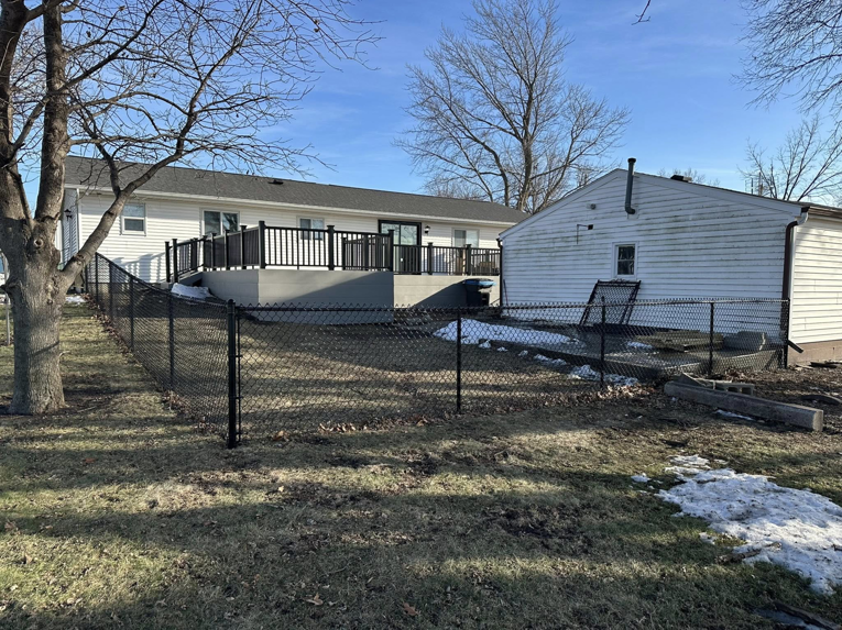 A newly installed black chain-link fence enclosing a backyard, completed by JD Fencing LLC in Boone, IA.