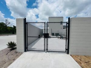 A black chain-link fence with a double gate installed for security by Boost My Home in St. Augustine, FL.