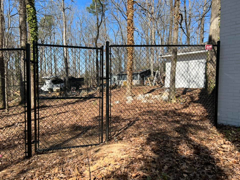A black chain-link fence with a double gate installed for a property by Allen Fences & Decks, LLC in Tuscaloosa, AL.