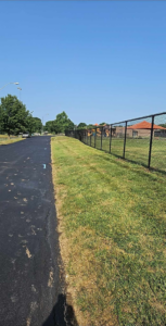 A newly installed black chain-link fence enclosing a playground area, installed by Atchison Fence in Effingham, KS.