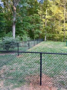 A durable black chain-link fence installed in a residential backyard by Cavitt Fencing in Concord, NC.
