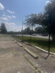 A black chain link fence installed along a commercial parking lot by Cameron Fence Builders in Indianapolis, IN.