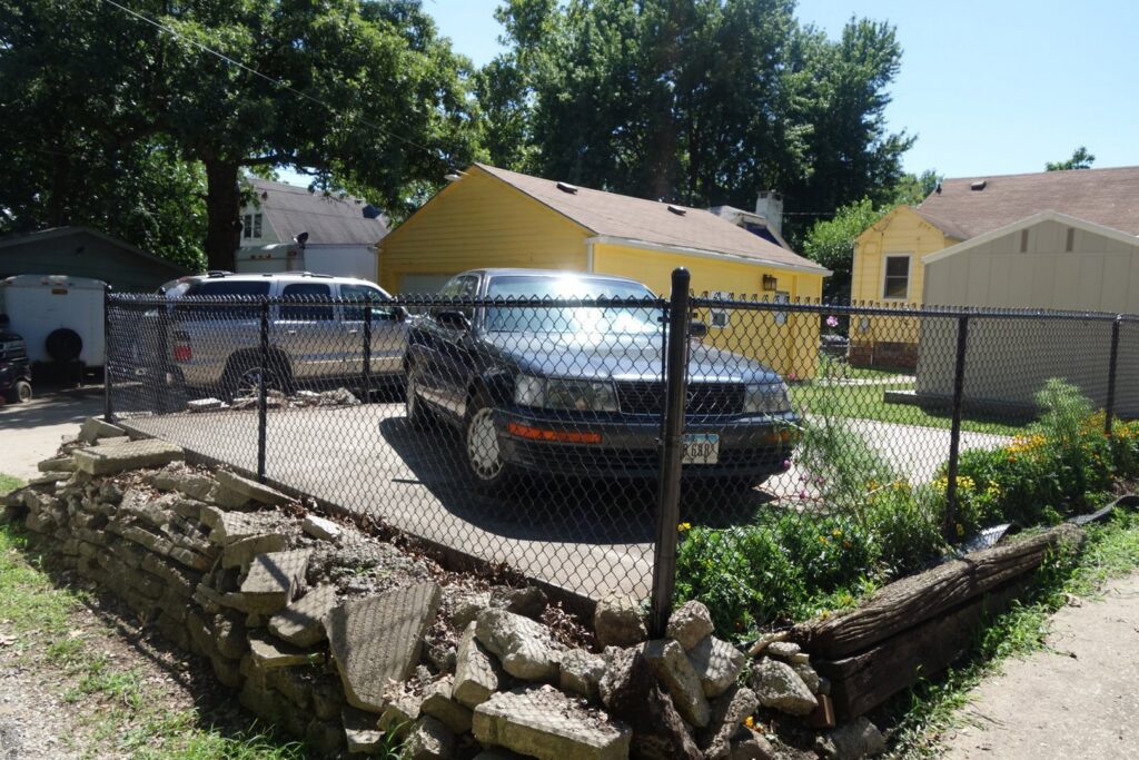 A black chain-link fence enclosing a residential driveway, installed by Stallworth Home Improvement in Des Moines, IA.