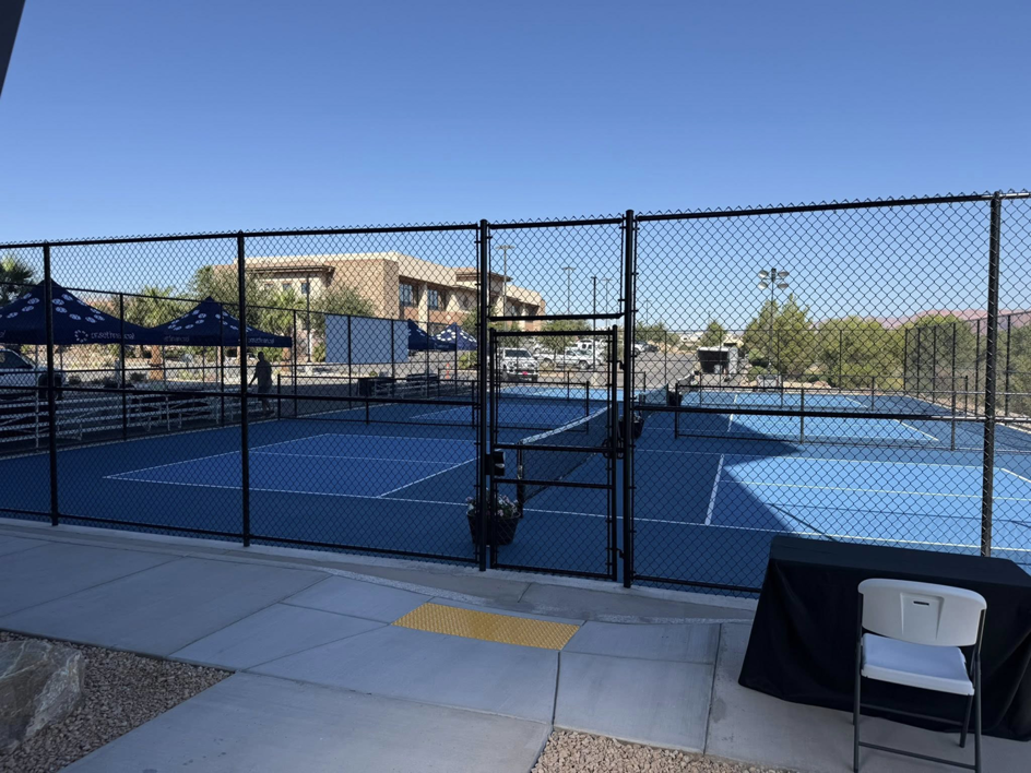 A black chain-link fence with a gate enclosing multiple pickleball courts installed by Legacy Fencing LLC in St. George, UT.