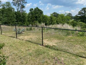 A black chain-link fence installed in a grassy area by Covenant Fence in Columbia, SC.