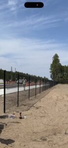 A long black chain-link fence recently installed along a roadside by Gaines Fence in Jacksonville, FL.