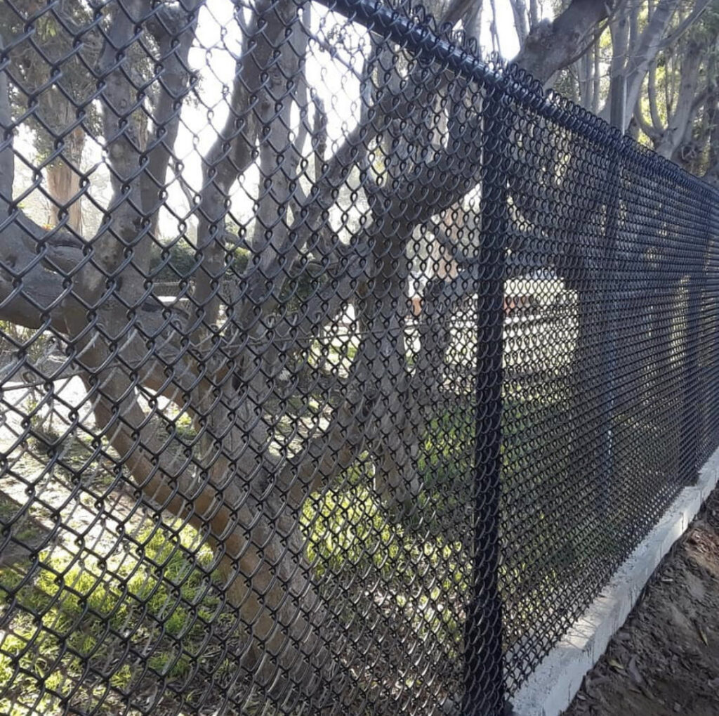 A durable black chain-link fence installed along a property line by Los Angeles Fence Builders in Los Angeles, CA.