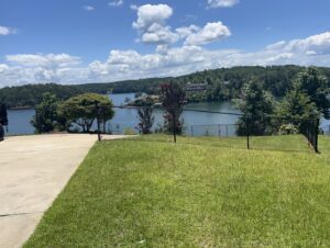 A newly installed black chain-link fence along a beautiful lakefront property by Premier Fence of Birmingham, LLC in Warrior, AL.