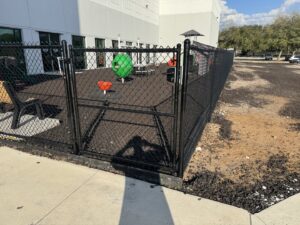 A durable black chain link fence enclosing a playground area, installed by Fence Nation LLC in Jacksonville, FL.