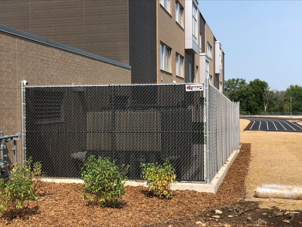 A black chain-link fence with privacy slats installed by Northway Fence in Menomonee Falls, WI.