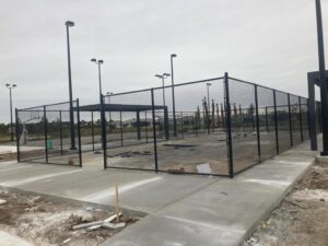 A black chain-link fence enclosing an outdoor sports court, installed by Allende J. Service Corp in Miami, FL.
