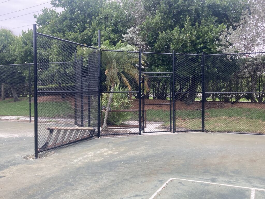 A black chain-link fence enclosing a tennis court, installed by Allende J. Service Corp in Miami, FL.