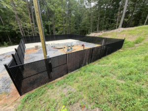 A secure black chain-link fence enclosing a utility area, installed by Alabama Fence & Rail LLC in Birmingham, AL.