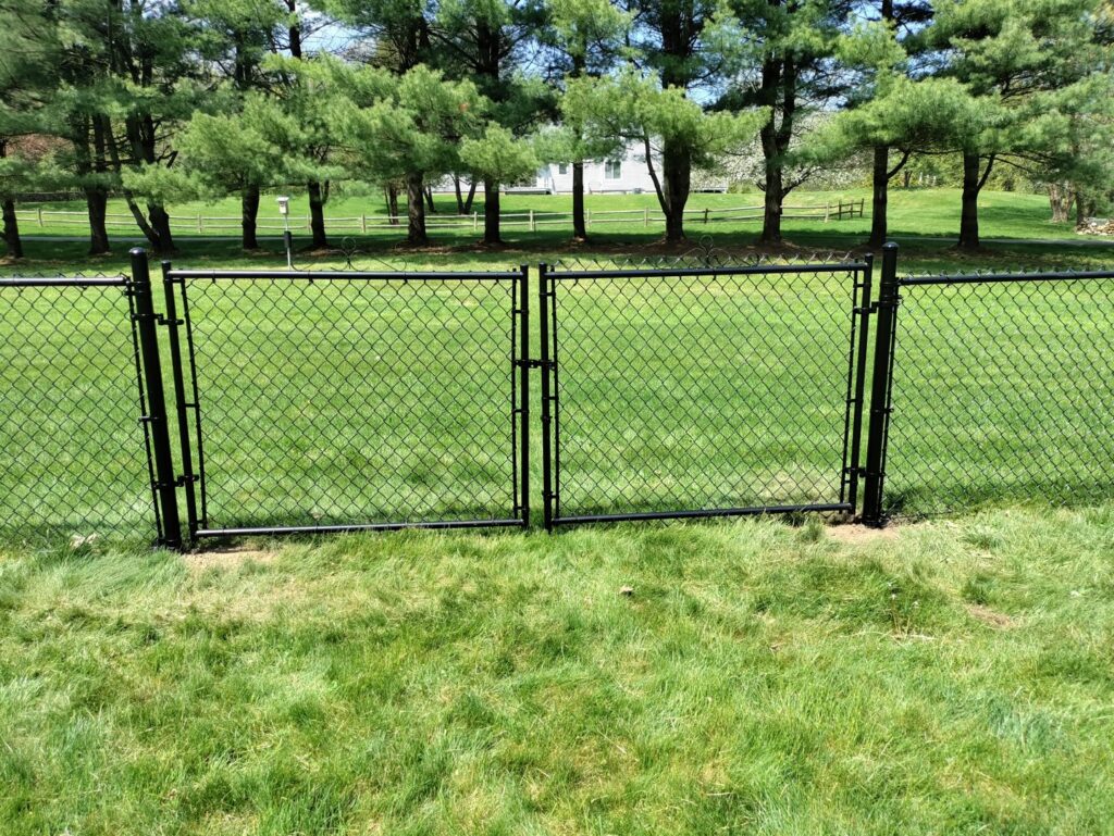 A durable black chain link fence with two gates installed by White Eagle Fence Inc in New Haven, CT.