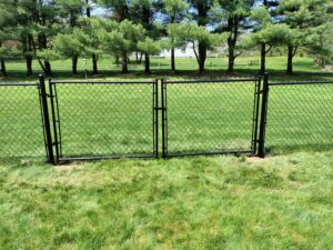 A durable black chain link fence with two gates installed by White Eagle Fence Inc in New Haven, CT.