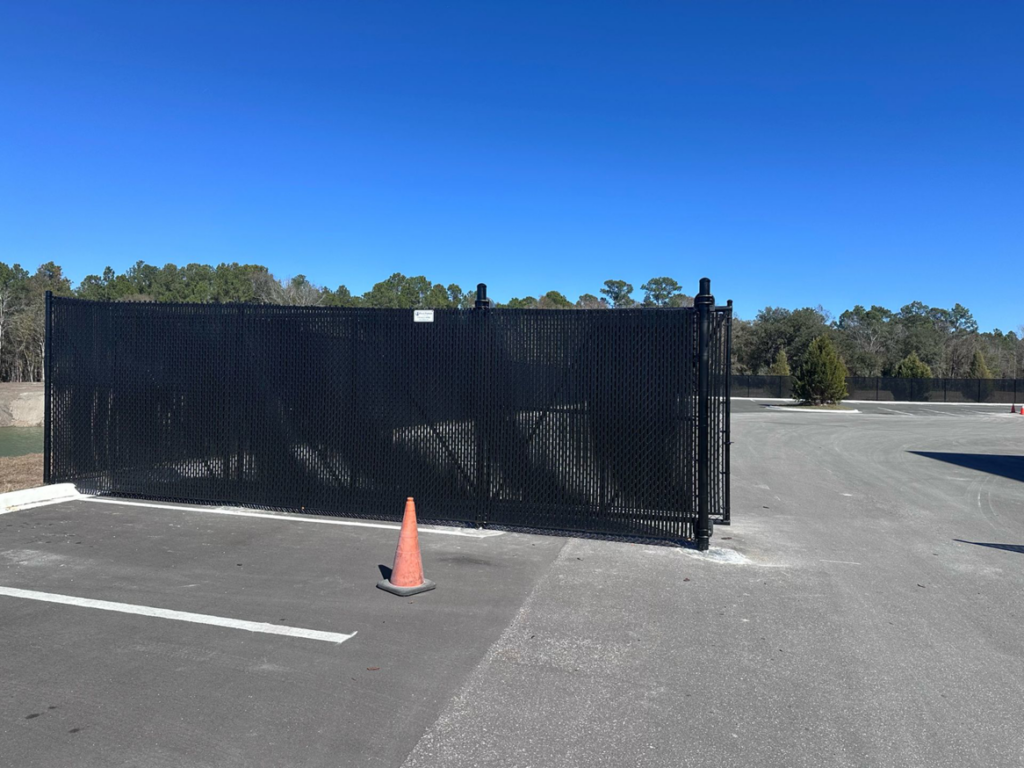 A black chain-link fence with privacy slats and a double gate installed by First Fence of Georgia in Kennesaw, GA.