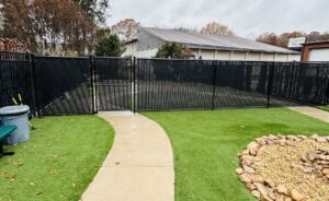 A black chain-link fence with privacy slats installed around a commercial property by Kelley Fence and Gate in Eva, AL.