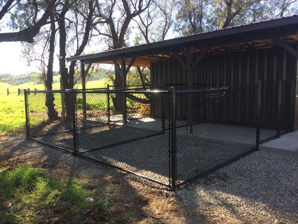 A black chain-link kennel or animal enclosure installed under a shelter by Horizon Fence & Custom Gates, Inc. in Orangevale, CA.