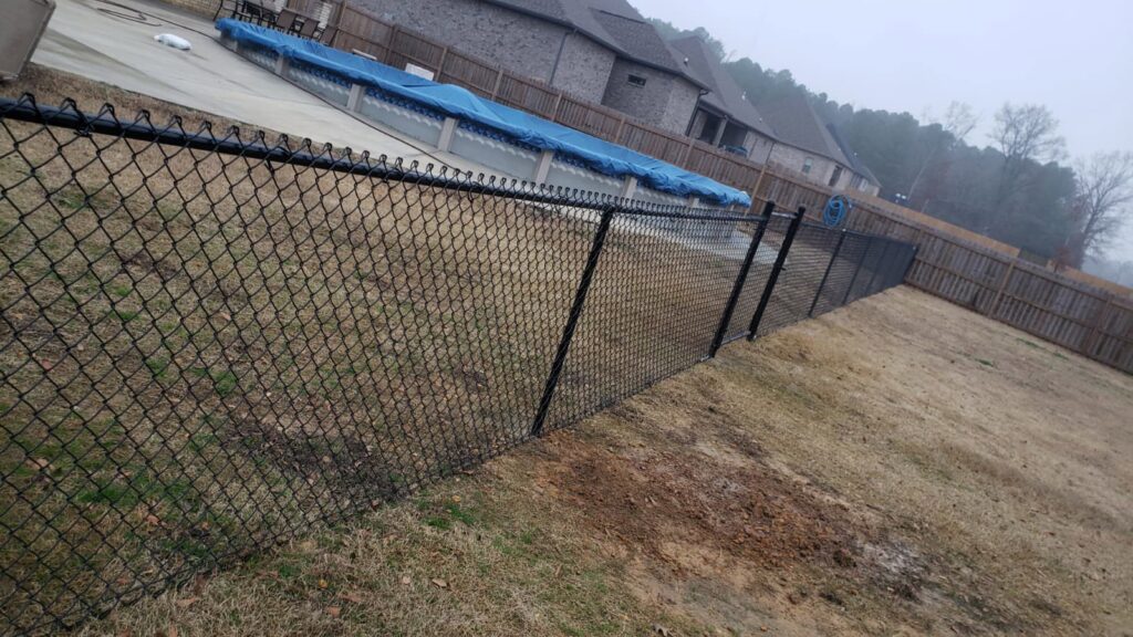 A black chain-link fence installed around a swimming pool by Fences & Landscape Inc in Little Rock, AR.