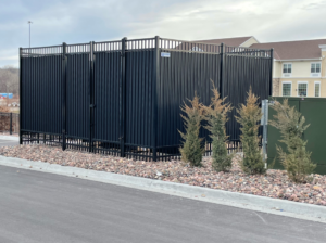 A black commercial privacy fence enclosure installed by Mann Fence Co., Inc. in Olathe, KS.