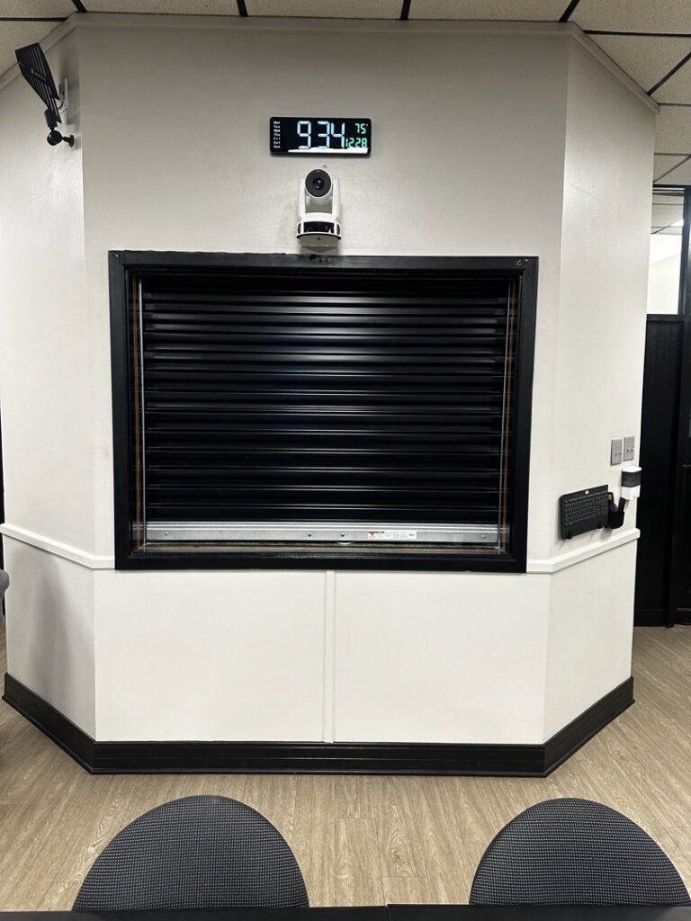 A black commercial security roll-up door installed in an office setting by Geaux Overhead Door in West Monroe, LA.