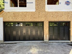 Black double and single garage doors with windows installed on a new build by Remarkable Door Company in Spokane, WA.