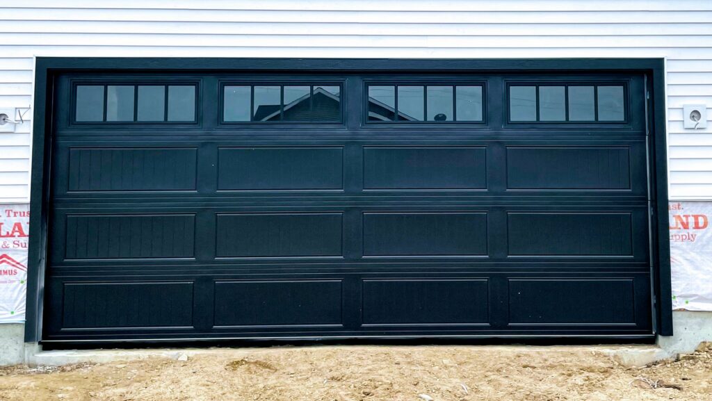 New black garage door with windows installed on a home under construction by Superior Overhead Door, LLC in Granger, IN
