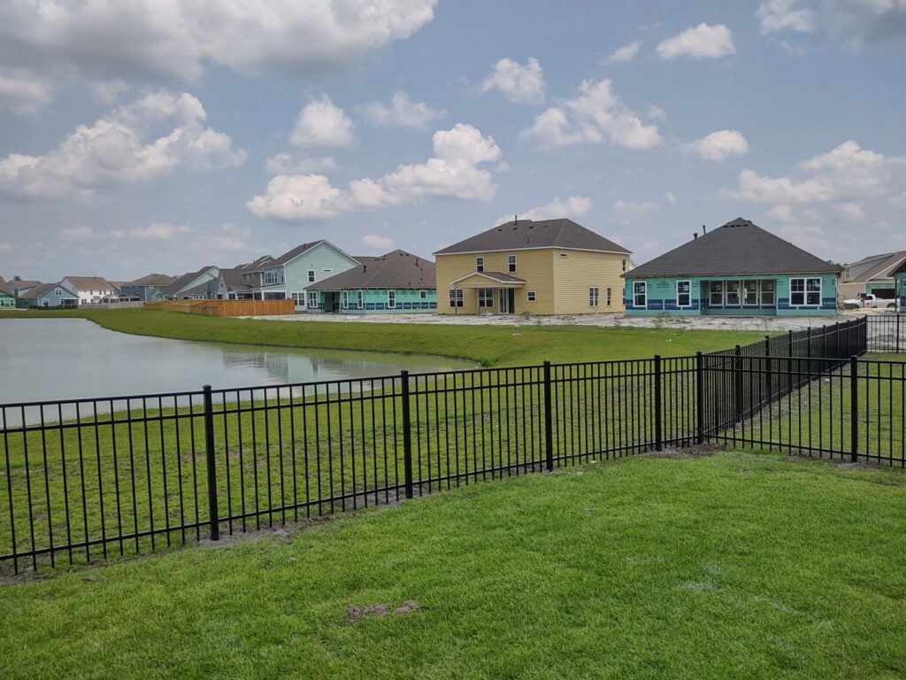 A black ornamental iron fence installed along a waterfront property by JB FENCE Brothers company llc in North Charleston, SC.