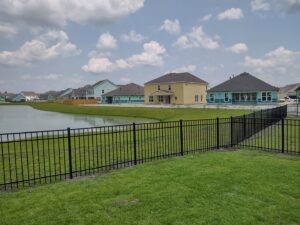 A black ornamental iron fence installed along a waterfront property by JB FENCE Brothers company llc in North Charleston, SC.