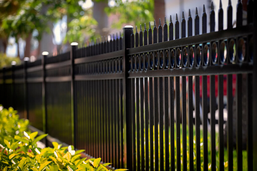 A black iron perimeter fence with decorative elements installed by Ironcraft Welding in Chicago, IL.