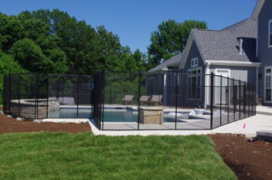 A black mesh safety fence installed around a swimming pool by Custom Design Fence & Deck, Inc. in Ofallon, MO