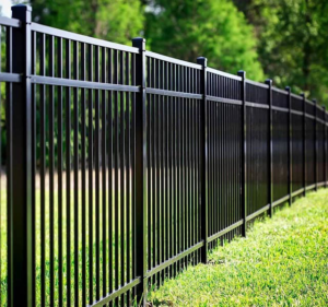 A long black metal or aluminum fence installed in a green lawn by Vanguard Fencing LLC in Lenexa, KS.