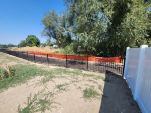 A combination of black metal and white vinyl fencing installed by Josey's Fencing LLC in Caldwell, ID.