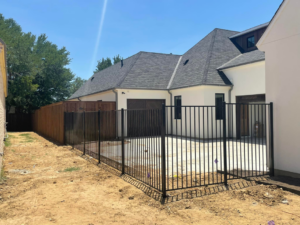 A combination of black metal and wood fence installation around a patio area by 3M Custom Fence in Lewisville, TX.