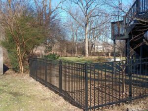 A durable black metal fence installed in a residential backyard by Affordable Fence Builders in Dayton, OH.