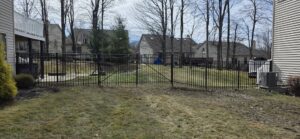 A black metal fence installed in a residential backyard by Affordable Fencing in Parma, OH.