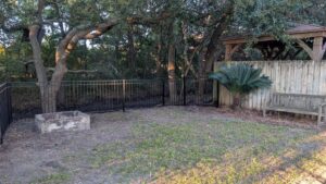 A black metal fence installed in a backyard by Gifford Contracting & Repair - Custom Privacy Fencing in Goose Creek, SC.