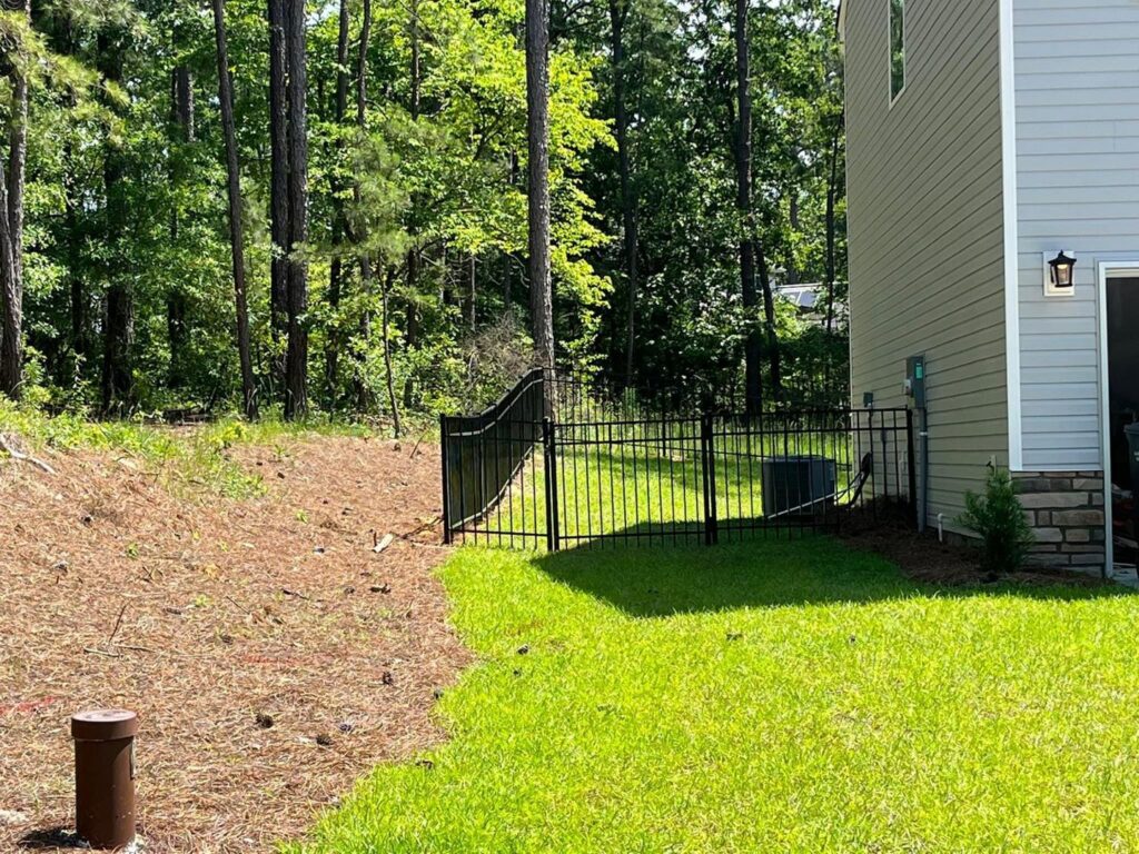 A black metal fence installed in a residential backyard by JB Nealy Fence in Elgin, SC.