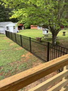 Durable black metal fence installed in a spacious backyard by Sunrise Fences, offering elegant security in Goose Creek, SC.