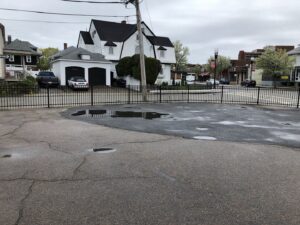 A black metal commercial fence enclosing a parking lot area by OMA Fence,LLC in Weymouth, MA