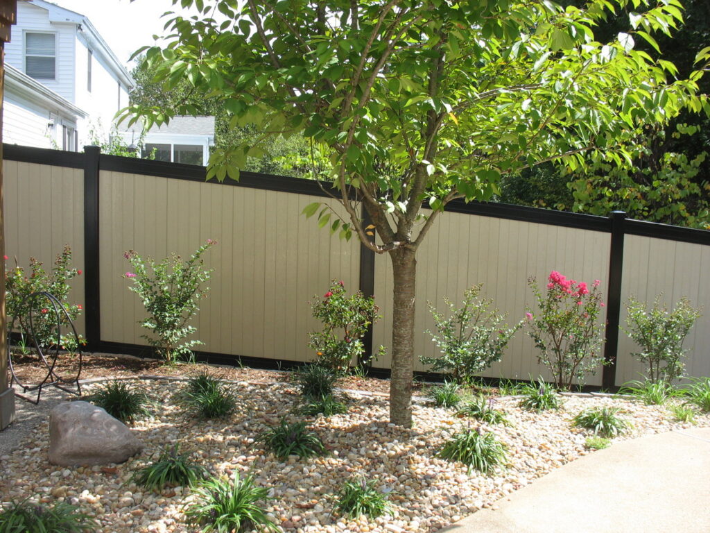 A black metal deck railing providing safety and a clear view of a lake and pool, installed by Custom Design Fence & Deck, Inc. in Ofallon, MO