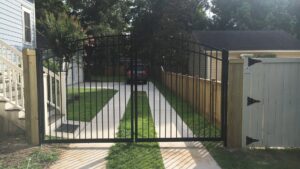 A new black metal double gate installed at a residential driveway entrance by Charleston Fencing Services in Moncks Corner, SC.
