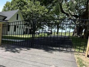 A black metal driveway gate installed at a residential property by Morton Fence Solutions LLC in Indianapolis, IN.