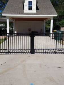 A black metal gate installed across a residential driveway by Superior Fence and Rail of Little Rock, AR