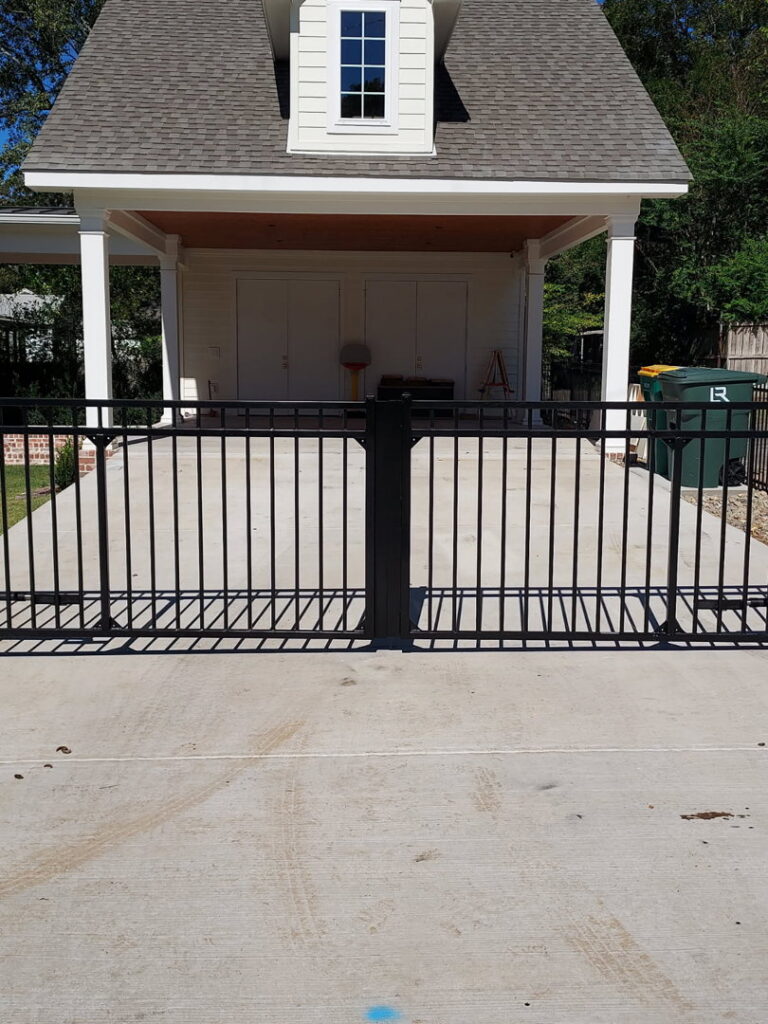 A black metal gate installed across a residential driveway by Superior Fence and Rail of Little Rock, AR