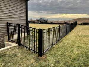 A black metal fence installed around a basement egress window by Custom Vinyl Fabrication in Omaha, NE.